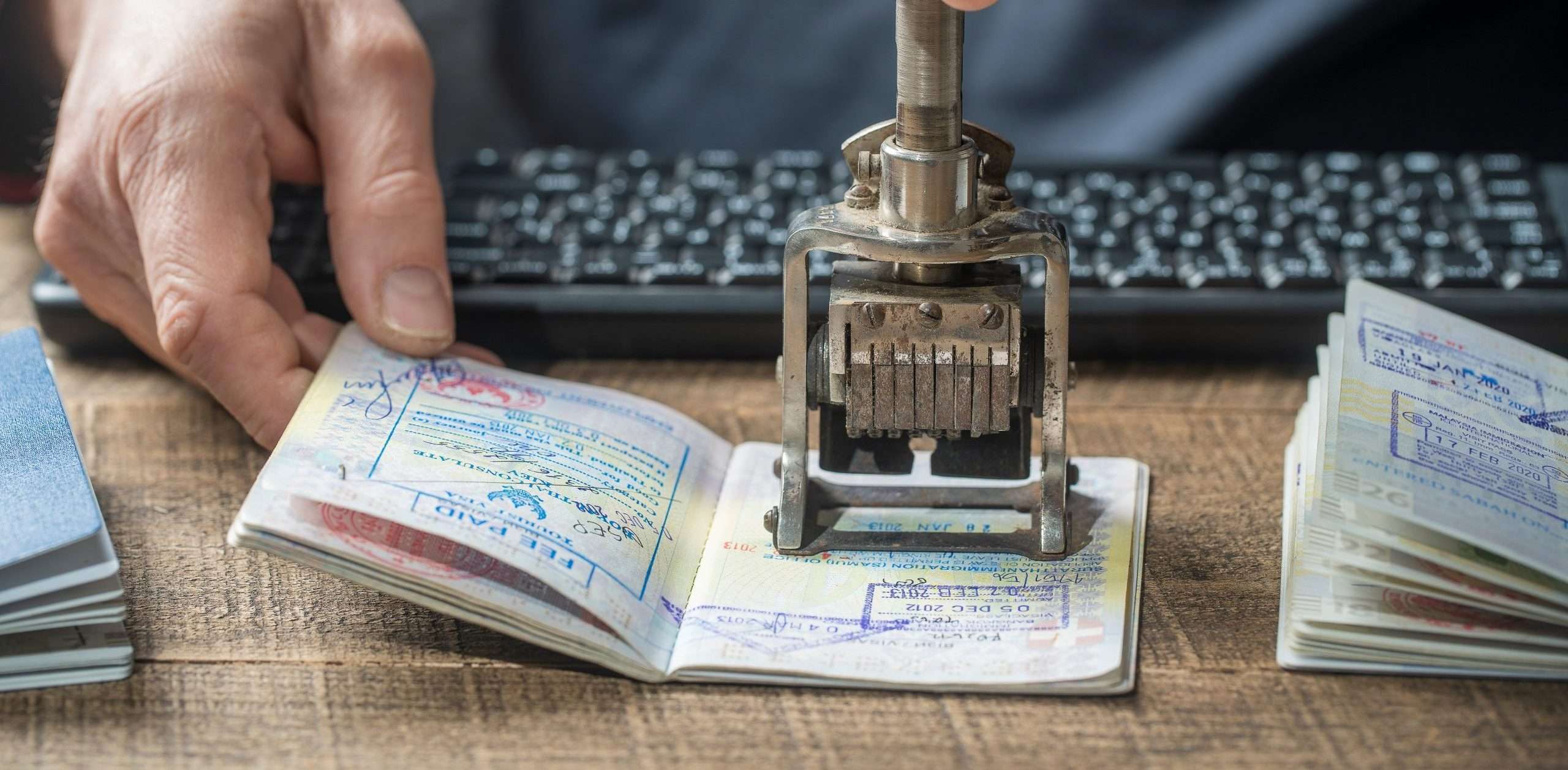 Immigration and passport control at the airport. Man border control officer puts a stamp in the international passport, close up. Vacation and travel concept